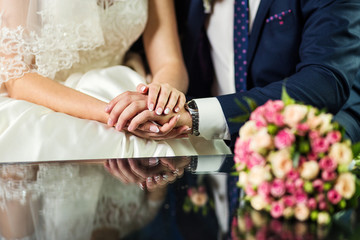 Obraz na płótnie Canvas loving couple holding hands on the wedding day
