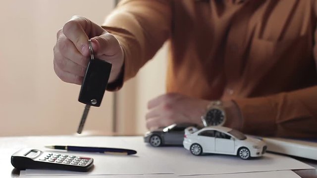 Dealer handing the owner the keys to the car. Concept of trade and car leasing
