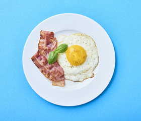 tastu fried egg in plate with bacon