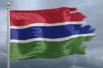 Obraz premium Gambia Flag with torn edges in front of a stormy sky