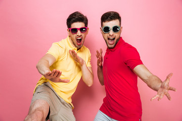 Portrait of an excited gay male couple in sunglasses