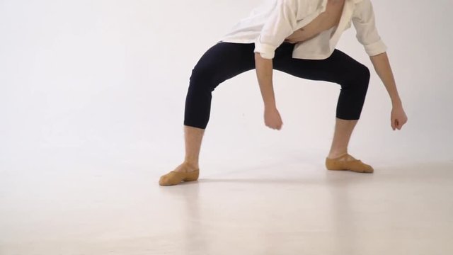 A man in ballet dancing on a white background. Rond de jambe par terre