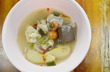 boiled chicken in hot and spicy tom yum soup on bowl