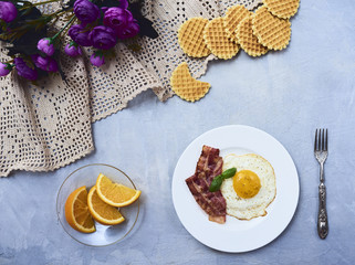 tastu fried egg in plate with bacon