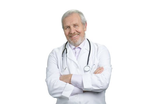 Portrait of old doctor with folded arms and stethoscope. White isolated background.