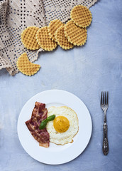 tastu fried egg in plate with bacon