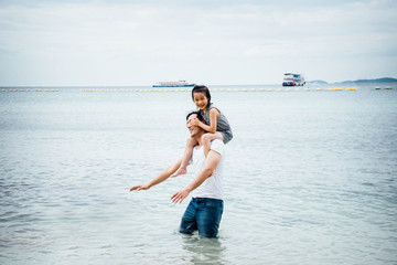 Father and daughter having fun on beach