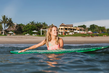 portrait of young woman in swimming suit with surfing board in ocean