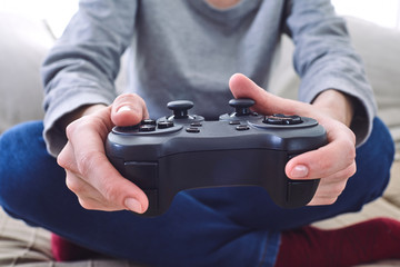 man holding a joystick controllers while playing a video games at home