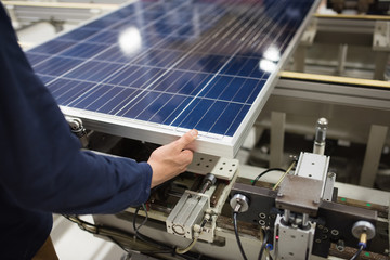 production of solar panels, man working in factory.