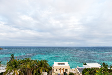 Fototapeta premium Villa on tropical sea beach in philipsburg, sint maarten. Beach vacation at Caribbean. Wanderlust, adventure and travel. View of blue sea on cloudy sky, nature