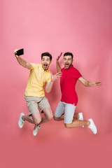 Fototapeta na wymiar Full length portrait of an excited gay male couple