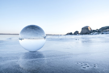 Glass orb on a frozen lake in the winter