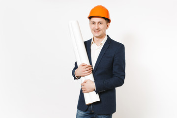 Young handsome smiling businessman in dark suit, protective construction orange helmet holding blueprints plans isolated on white background. Male worker for advertisement. Business, working concept.