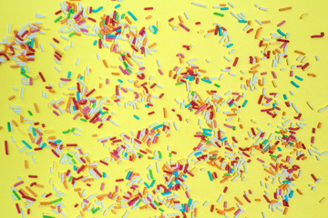 Fototapeta na wymiar Multicolored confetti on a yellow background top view
