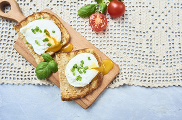Tasty poached egg on toast over rustic background