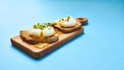 Tasty poached egg on toast over rustic background