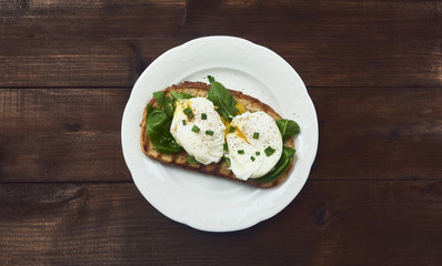 Tasty poached egg on toast over rustic background