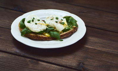 Tasty poached egg on toast over rustic background