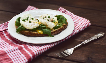 Tasty poached egg on toast over rustic background