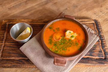 Marmitako soup in a ceramic bowl on a wooden board