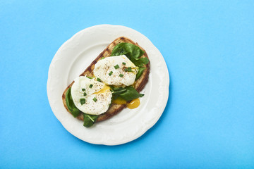 Tasty poached egg on toast over rustic background