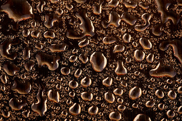 Colored water droplets on a gold background. Abstract liquid sprays