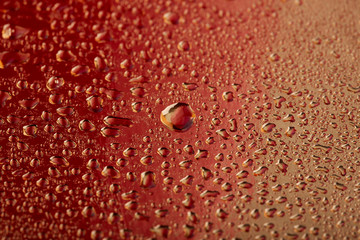 Colored water droplets on a gold background. Abstract liquid sprays