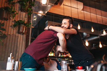 Multiracial men meeting their friend in lounge cafe. Real emotions of best friends happy to see each other.