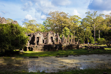 Fototapeta na wymiar ancient public temple with tourist walk around and small lake infront with blue sky in cambodia
