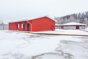 low red wooden building in winter field 