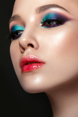 Beautiful woman portrait with bright colorful make up on black background.