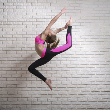 acrobat teen girl in a tracksuit jumping