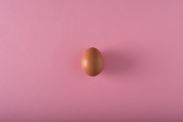 Minimalism. one egg in the center on a light pink background