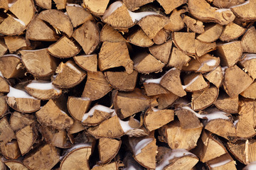 Firewood is stacked in a woodpile, background and texture.