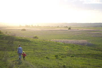 Fototapeta na wymiar Ukraine. End of april. Sunset: field and mom with daughter. 