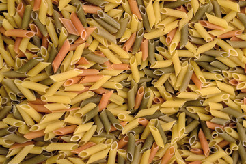 Texture of multicolored pasta in the shape of tubes