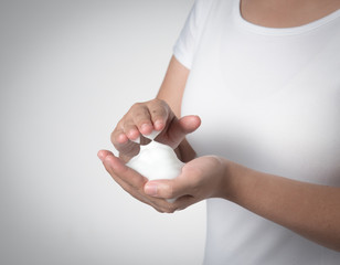 Shave foam (cream) on woman's hands,against gray background