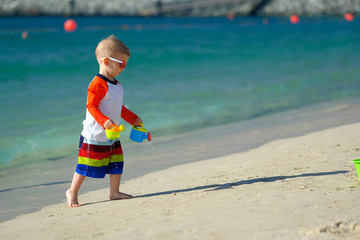 Two year old toddler playing on beach