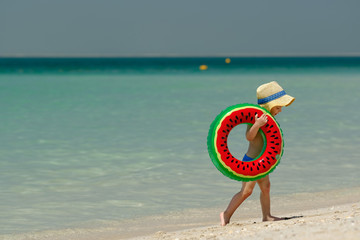 Fototapeta na wymiar Toddler boy with swim ring on beach