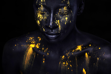 Fröhliche junge Afrikanerin mit Kunstmode-Make-up. Eine erstaunliche Frau mit schwarzem Make-up und auslaufender gelber Farbe