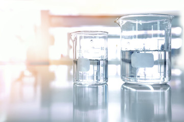 two clear glass beaker experiment with clean water in chemical science laboratory background with...