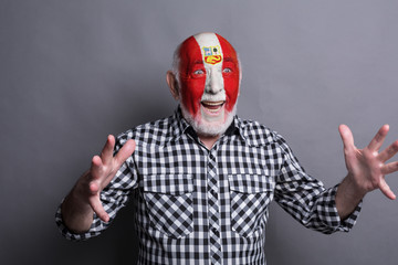 Senior man with Peru flag painted on his face