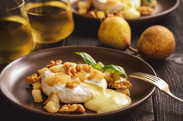 Baked camembert with pears and walnuts, served with white wine.