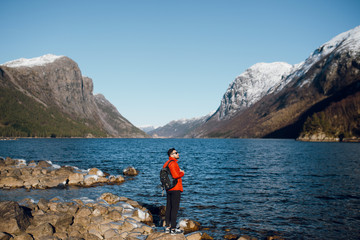 Fototapeta na wymiar Man standing on the stones alone at fjord in Norway, Travel lifestyle emotions vacations outdoor, scandinavian nature