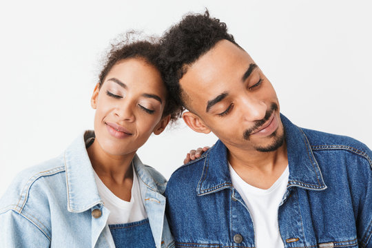 Pleased lovely african couple in denim shirts posing together
