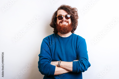 Portrait Of Cheerful Bearded Hipster Man With Long Curly Hair And