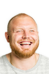 Obraz premium Cute young man with a beard laughing, close-up, isolated