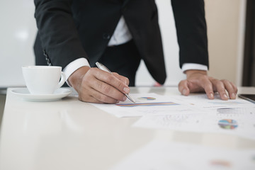Hand of businessmen write business document charts at office desk. He are analyzing. brainstorming concept..