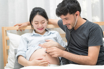 Fototapeta premium In Selective Focus Of Happy Family Checking New Baby In The Morning.Close Up Of A Beautiful Happy Pregnant Woman With Big Belly. Pregnancy And Motherhood Moment People And Expectation Concept.